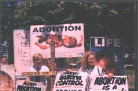 Pro choice league Bill Baird and friend. Saints in back holding signs at press confrence across from NRTL convention.