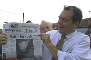 Flip holding todays newspaper you can read the headline "Battle for Souls"